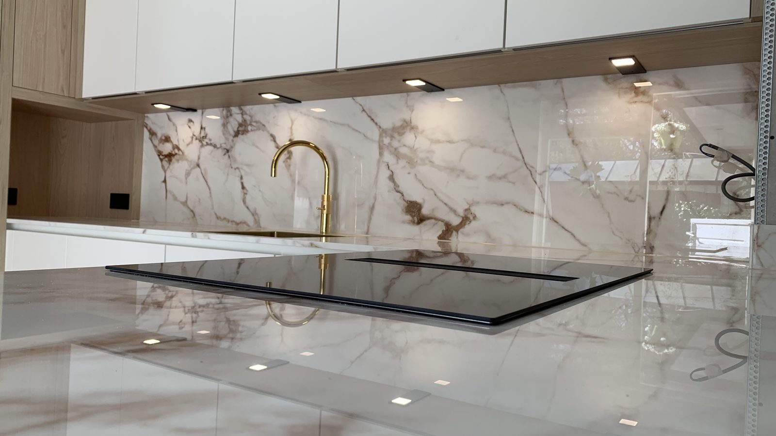 Greeploze witte keuken met keramische wand in marmerlook